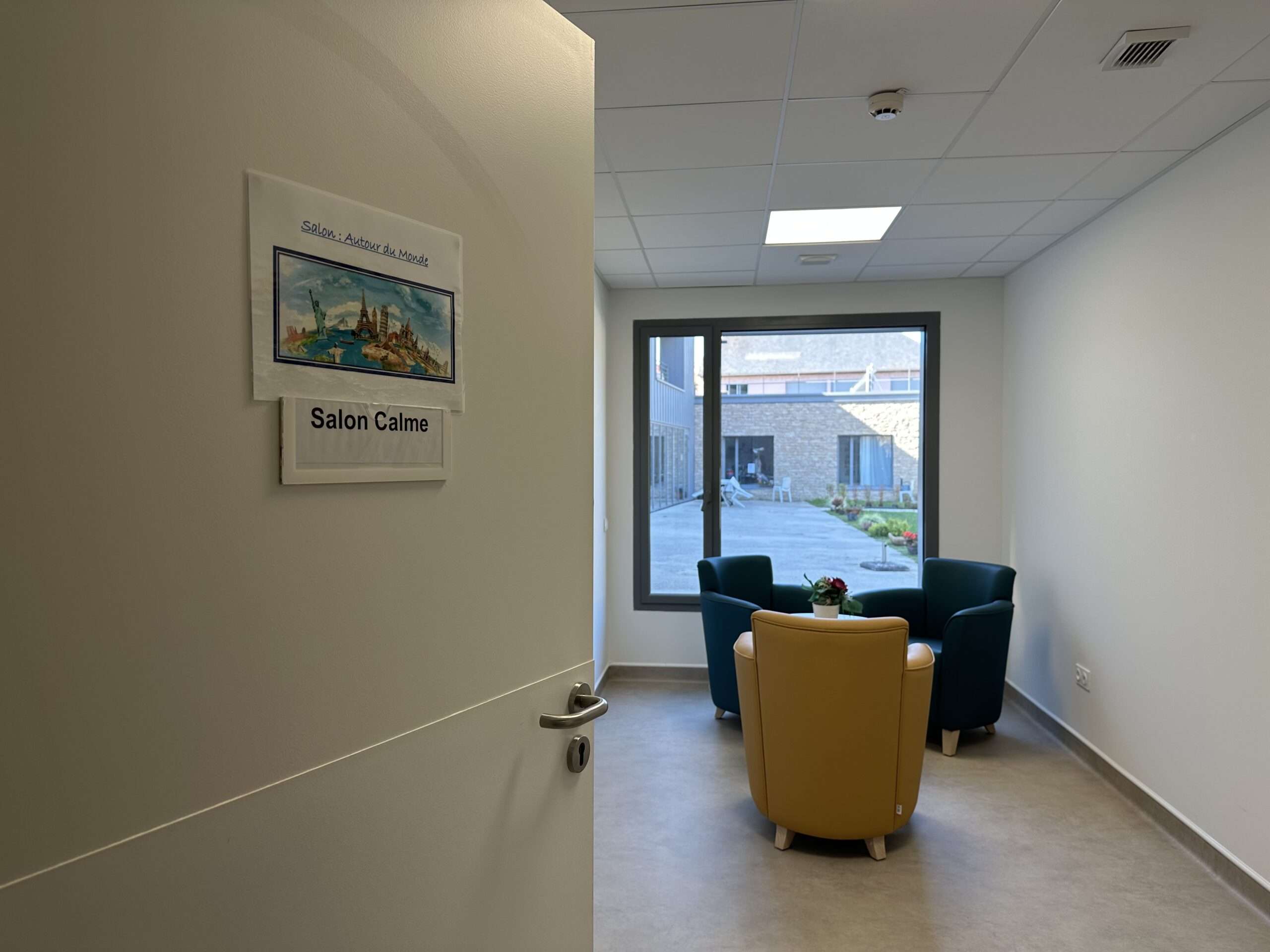 Salon calme avec vue extérieure sur la cour de l'EHPAD